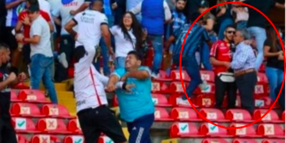 Fan del Atlas intenta calmar a su abuelo, durante la pelea en el Estadio Corregidora.