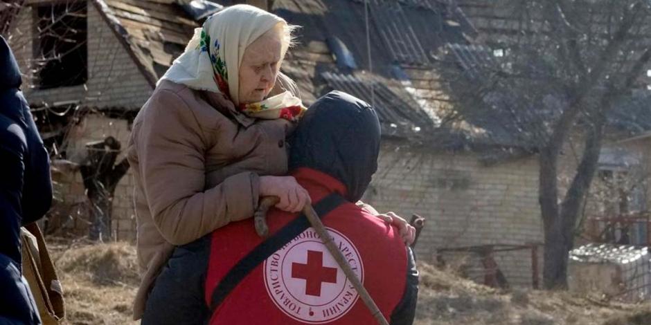 Un trabajador de la Cruz Roja traslada a una anciana durante la evacuación de Irpin, a unos 25 kilómetros al noroeste de Kiev