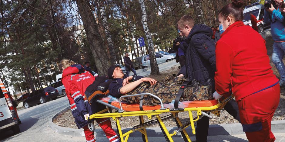 Personal de emergencias  traslada a soldados heridos en la base de Yavoriv.