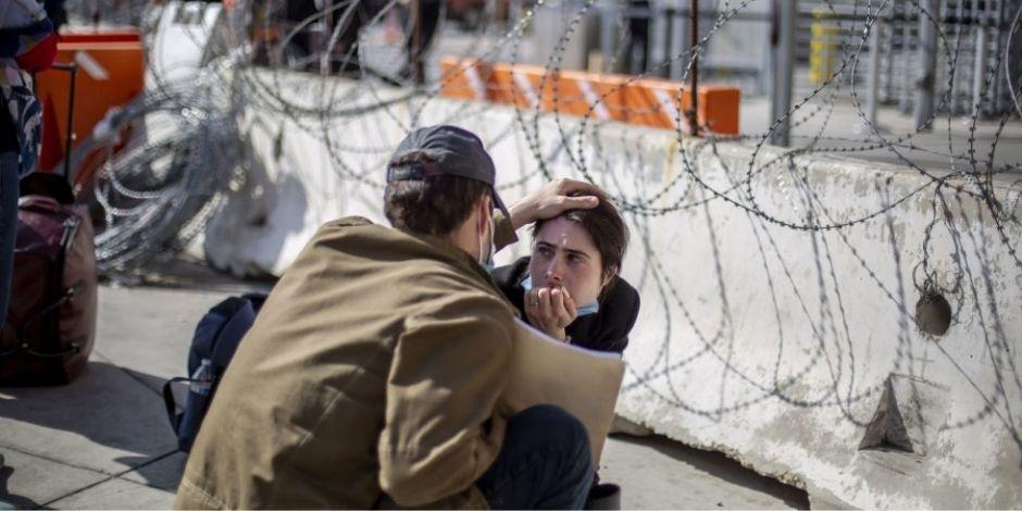 Pareja de refugiados en el puerto fronterizo de San Ysidro mientras esperan a solicitar asilo a EU.