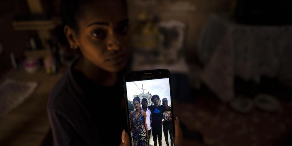 Una cubana muestra una foto de su esposo y hermanos, encarcelados tras ser acusados de participar en las protestas.
