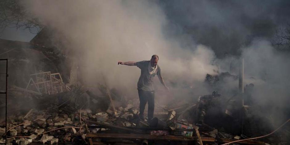 Un hombre camina entre los restos de una casa destruida por un ataque ruso, en Járkov, Ucrania