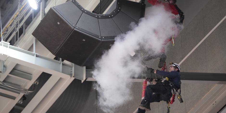 Bomberos utilizan un extintor de incendios en un grupo de altavoces que cuelgan del techo de la Scotiabank Arena, donde los Raptors juegan sus partidos como locales en la NBA.
