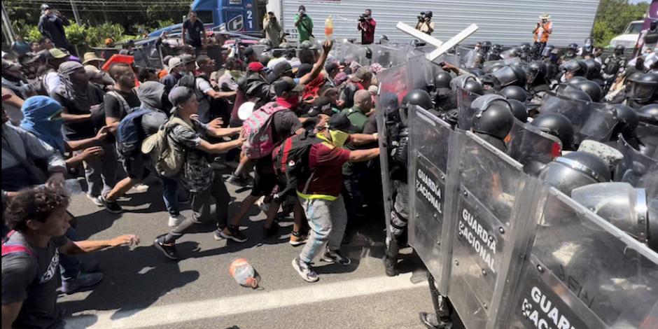 Caravana se enfrenta con elementos de la Guardia Nacional, ayer; tras el choque, fueron detenidas decenas de personas.