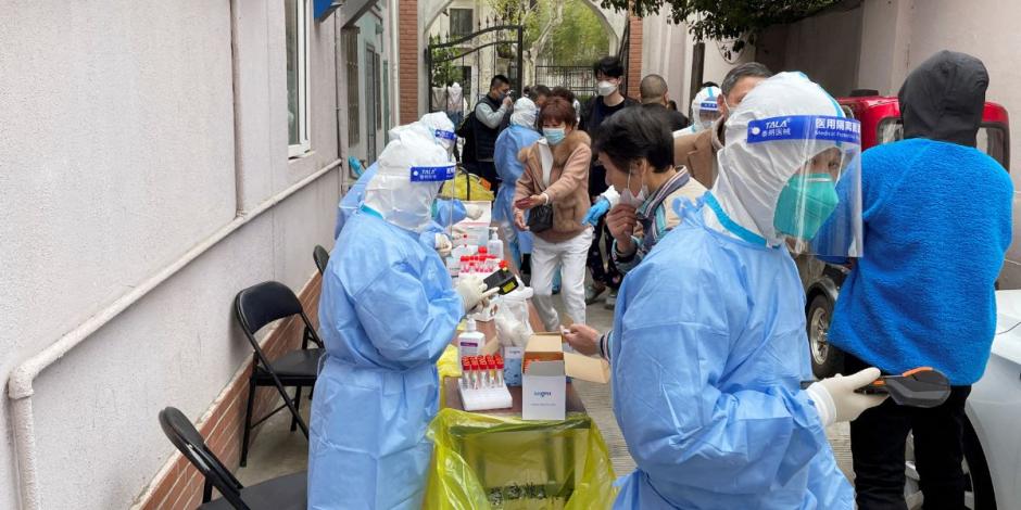 Trabajadores médicos con trajes protectores administran pruebas de ácido nucleico; buscan frenar la propagación de COVID-19 en Shanghái, China.