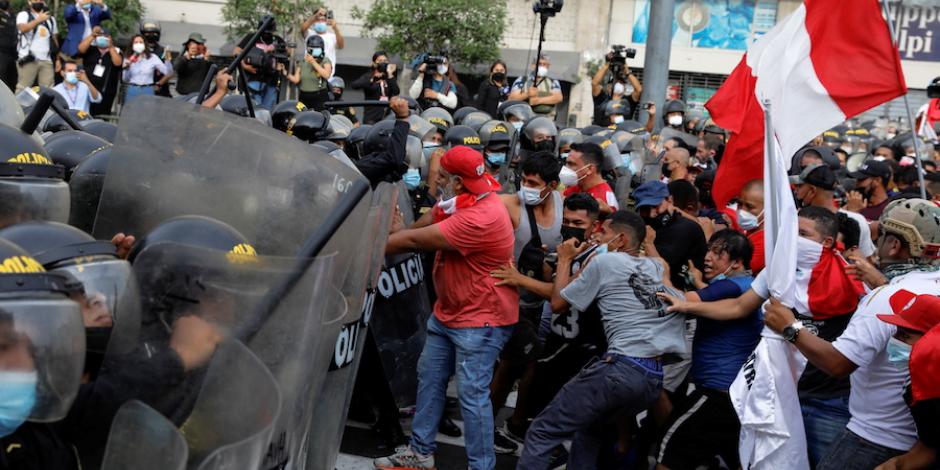 Policías responden con golpes a la confrontación con manifestantes en Perú, ayer.