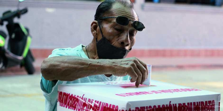 Una persona acude a votar durante la Jornada de Revocación de Mandato con cubrebocas para protegerse del COVID-19