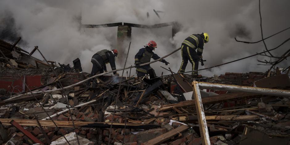 Bomberos buscan a posibles víctimas entre los escombros tras un ataque ruso en Járkov.