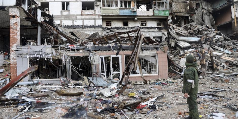 Un militar ucraniano observa el daño causado a un edificio en Mariupol, ayer.