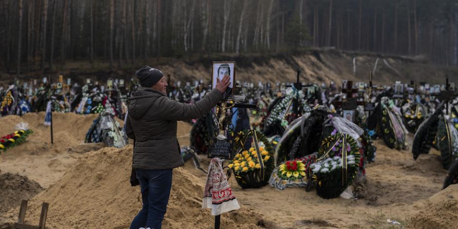 Una mujer toca una foto de su padre durante su funeral, en Kiev, ayer.