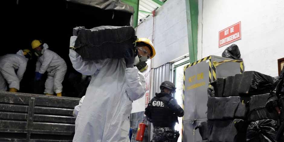 Trabajadores descargan sacos que contienen paquetes de cocaína de un camión antes de la incinerarlos en Ecuador el 21 de abril de 2022