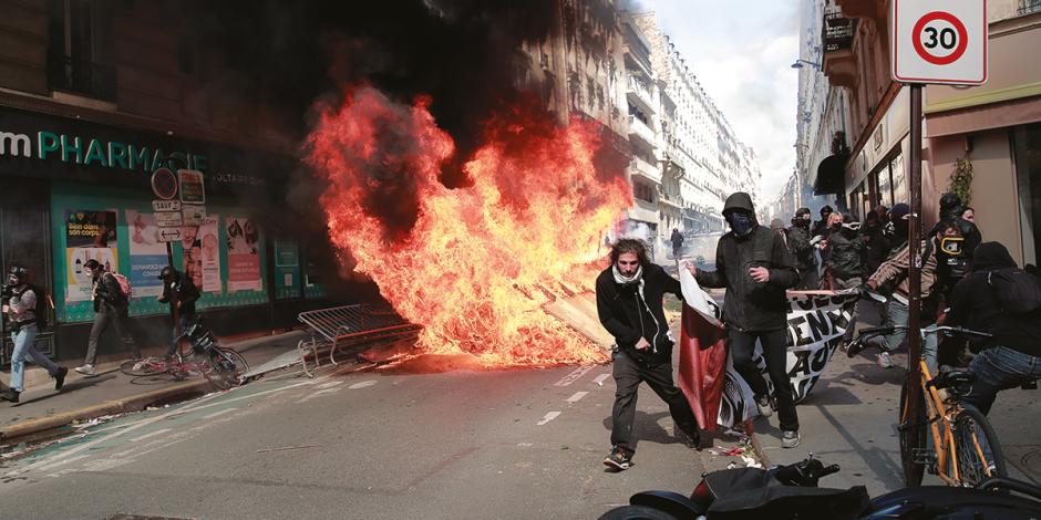 Vándalos prenden fuego a una barricada en calles de París.