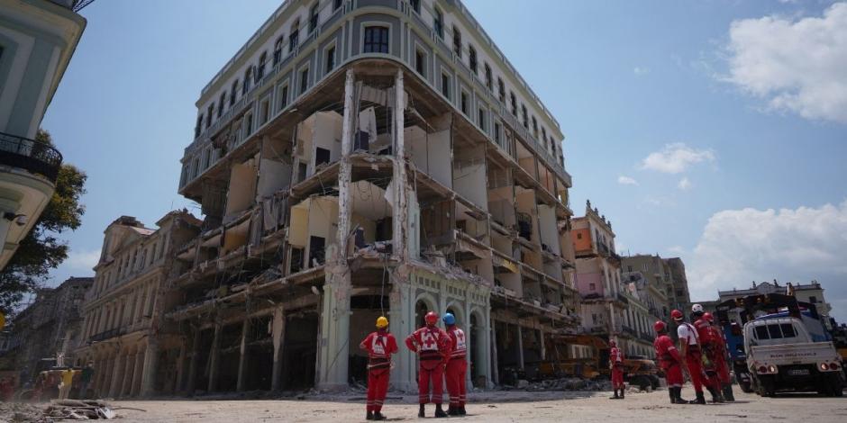 Personal de emergencia se para frente al Hotel Saratoga cuatro días después de que sufriera una explosión en La Habana.