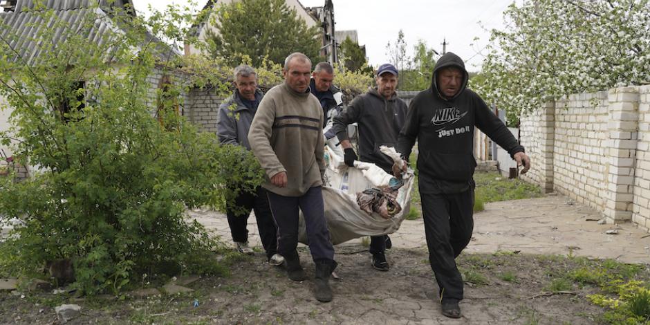 Ciudadanos ayudan en la recuperación de víctimas asesinadas por los ocupantes, en Járkov.
