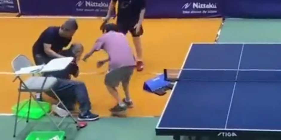 Hombre recibe raquetazo en la cara durante juego de dobles de ping pong