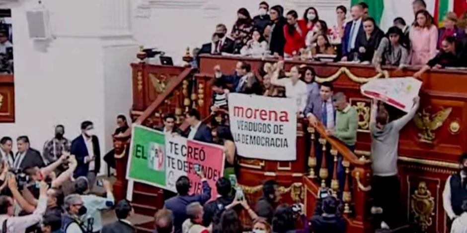 Con pancartas con la frase "Morena, verdugos de la democracia", los legisladores se subieron a la tribuna en un intento por frenar la discusión de la iniciativa