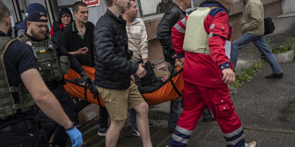 Voluntarios ayudan a transportar a un herido tras un ataque en Járkov, ayer.
