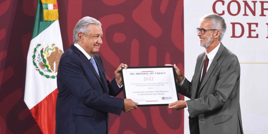 El Presidente López Obrador, al recibir el premio del representante de la OPS, ayer.