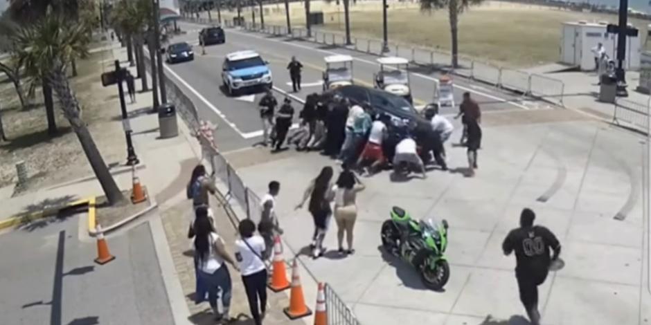 VIDEO: Lo chocan y queda bajo un auto; peatones se unen para levantar carro y sacarlo.