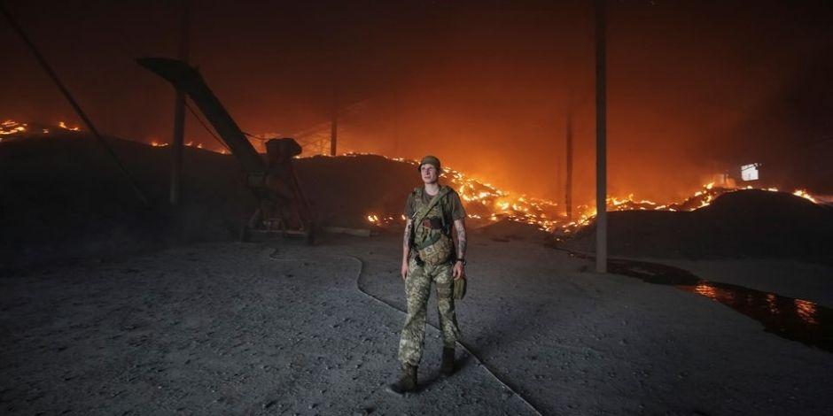 Soldado ucraniano camina durante incendio después de bombardeo ruso.