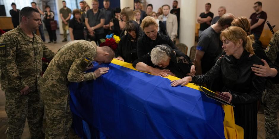 Familiares y compañeros de un coronel ucraniano muerto en combate lo despiden, ayer, durante un funeral en Zhytomyr.