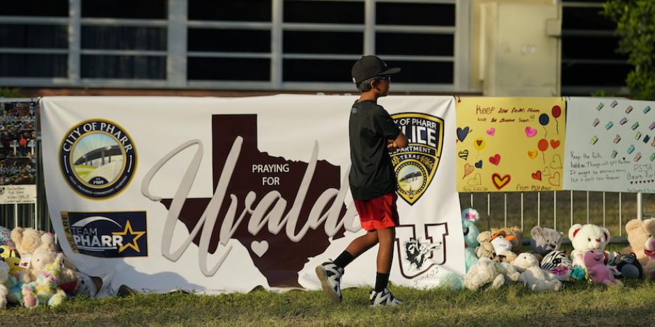 Un niño camina junto a un memorial afuera de la Escuela Primaria Robb, en Uvalde, Texas, ayer.