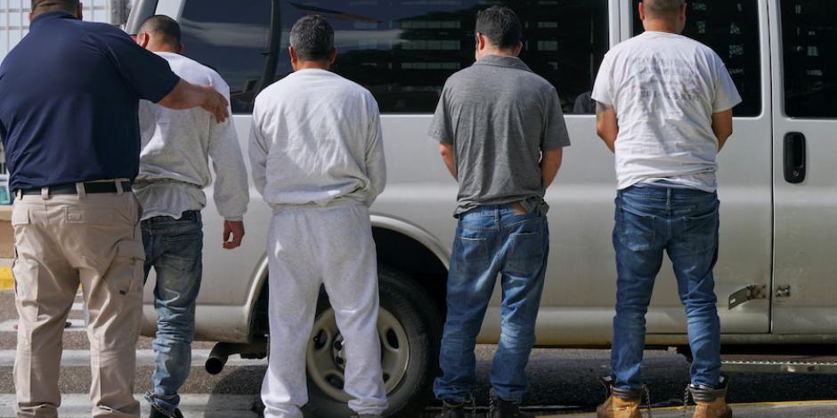 Indocumentados sujetos a deportación, con esposas en los pies.