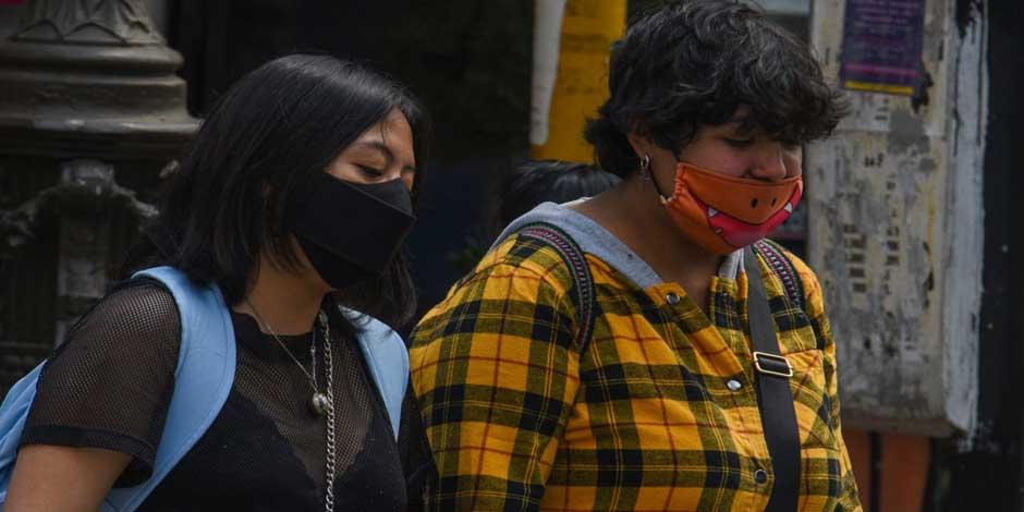 Un par de mujeres caminan por la calle utilizando cubrebocas para protegerse de la nueva ola de contagios por COVID-19