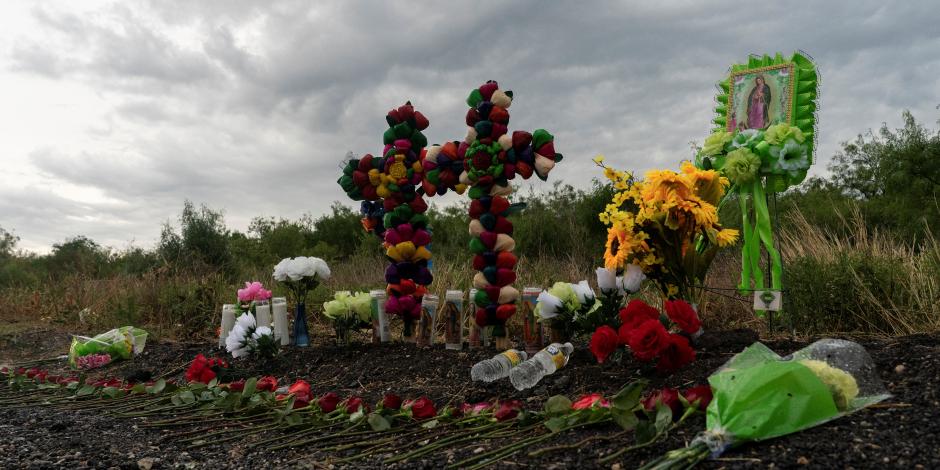Flores, velas y botellas de agua se colocaron en la escena donde 52 migrantes fueron encontrados muertos dentro de un camión de remolque en San Antonio, Texas