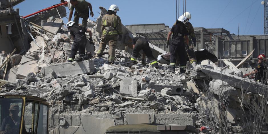 Bomberos ucranianos laboran en el edificio de departamentos que fue bombardeado en Odessa, ayer.
