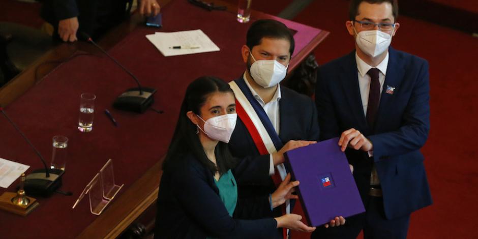El mandatario Gabriel Boric (centro) posa con la congresista María Elisa Quinteros con la nueva Constitución chilena.