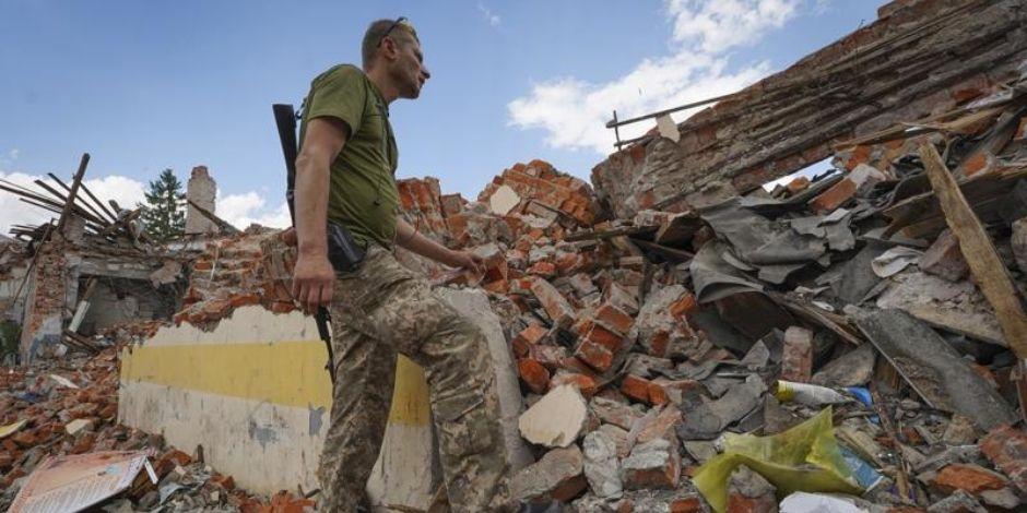 Un soldado ucraniano mira los escombros de una escuela en las afueras de Járkiv, Ucrania.