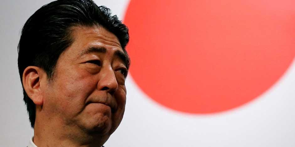El exprimer ministro Shinzo Abe, frente a la bandera nacional de Japón en imagen de archivo