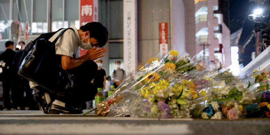 Una persona reza en el sitio donde le dispararon al exprimer ministro japonés, en Nara, Japón, ayer.