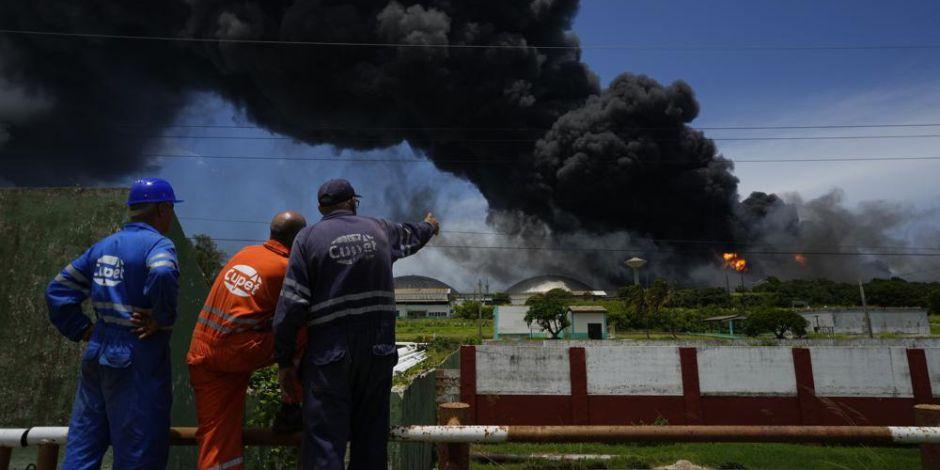 Trabajadores de CUPET observan una columna de humo que se eleva desde la Base de Superpetroleros de Matanzas, Cuba.