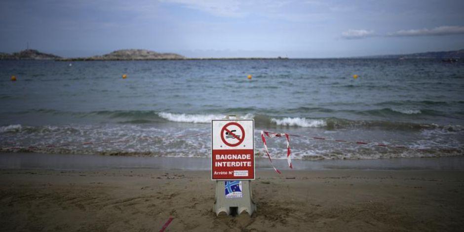 Un cartel anuncia que está prohibido entrar a nadar en la playa tras el paso de una tormenta en Marsella, Francia.
