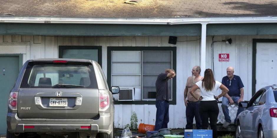 Vecinos alrededor de una instalación de alquiler de varias habitaciones después de un tiroteo en Houston.