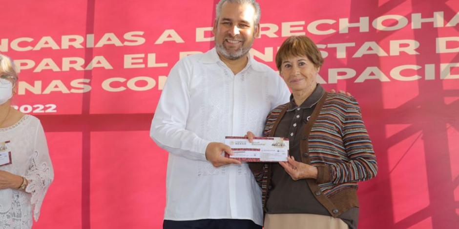 El gobernador de Michoacán, Alfredo Ramírez Bedolla, con una de las beneficiarias.