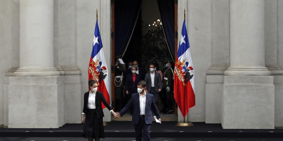El mandatario chileno de la mano de su esposa, Irina Karamanos, minutos antes de anunciar a su nuevo gabinete (que avanza detrás de él).