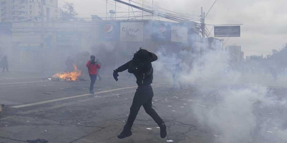 Un manifestante arroja un bote de gas lacrimógeno durante los enfrentamientos que estallaron durante una marcha para conmemorar el aniversario del golpe de Estado que derrocó al presidente Salvador Allende y llevó al poder al dictador Augusto Pinochet hace 49 años, en Santiago de Chile