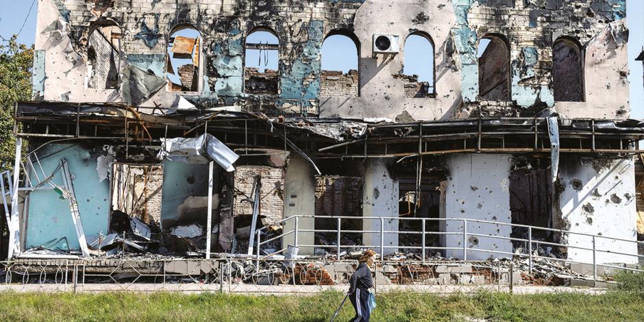 Una ciudadana pasa frente a un edificio destruido en Izium, territorio recuperado.