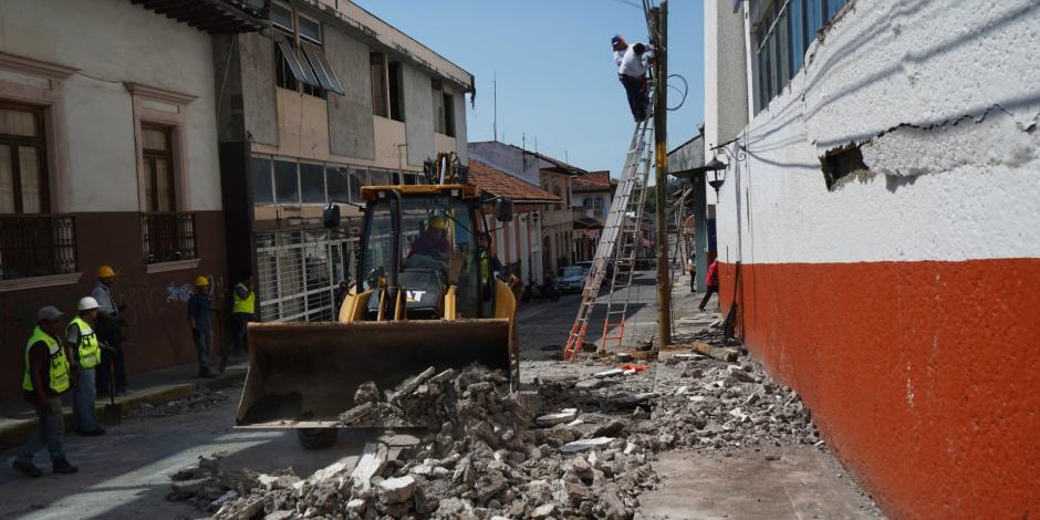 Trabajadores remueven los escombros que cayeron de un inmueble afectado en Uruapan, ayer.