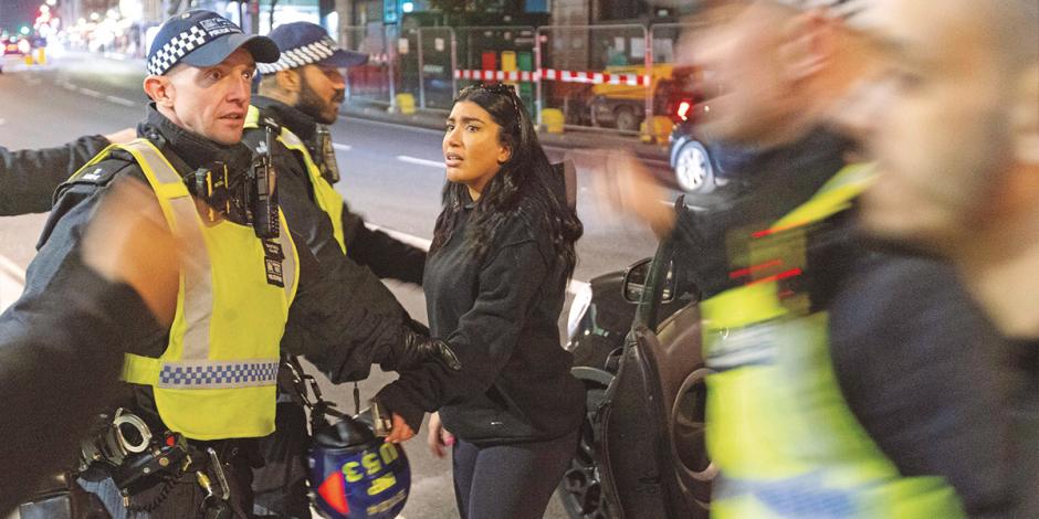 Oficiales confrontan a una mujer que intentó sumarse a las protestas, ayer.