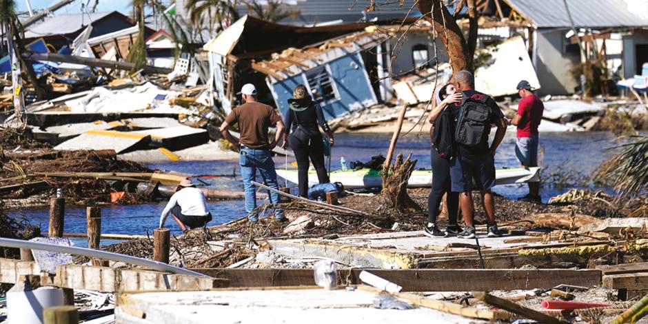 Ciudadanos atestiguan el daño causado en las costas de Florida, ayer.