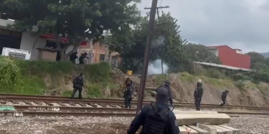 Durante el intento de bloqueo a las vías del tren en Caltzontzin, maestros y elementos de la Guardia Civil de Michoacán se enfrentaron con piedras, petardos y gas lacrimógeno