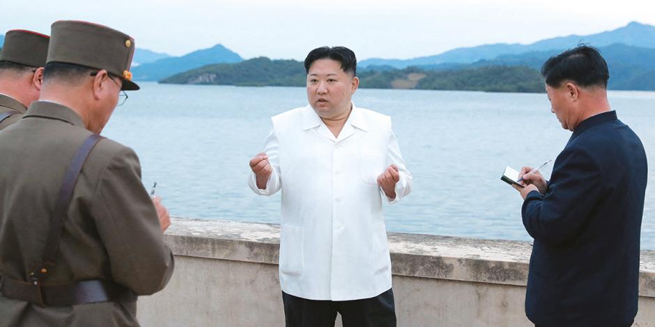 El líder norcoreano, Kim Jong-un (centro), da órdenes a mandos militares tras nuevos entrenamientos balísticos, ayer, en un sitio del que no se detalló la ubicación.