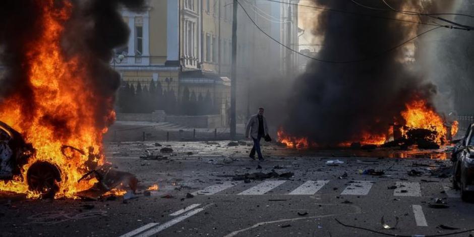 Automóviles se incendian después de que el ejército ruso bombardeó Kiev y unas 10 ciudades más en Ucrania, este lunes.