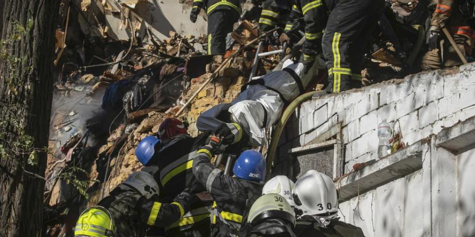 Bomberos sacan un cadáver de entre los escombros tras el ataque de un dron contra edificios residenciales en Kiev, Ucrania, el 17 de octubre de 2022.