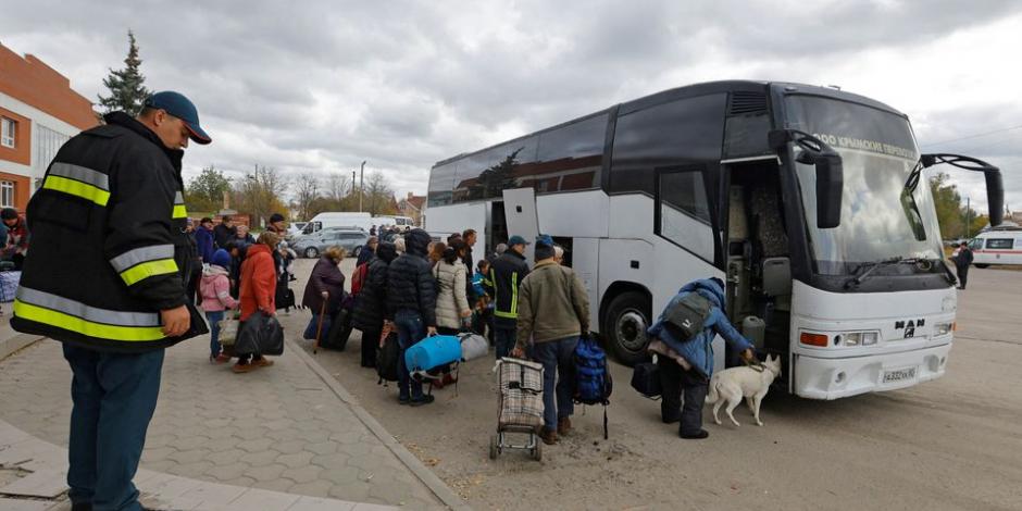 Los civiles evacuados de la ciudad de Jerson, controlada por Rusia, abordan un autobús que se dirige a Crimea.