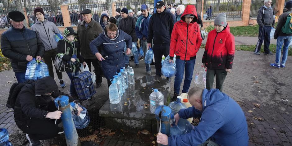 Ucranianos hacen fila en pozos para llevar un poco de agua a sus casas, ayer.